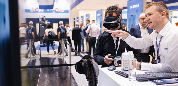 Zwei Person vor Monitor, einer davon mit VR-Brille